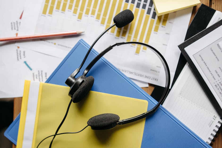 Close-up of an office desk with headset, charts, and documents showcasing customer service support.
